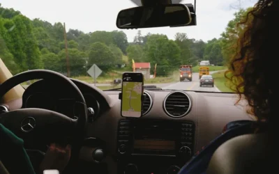 a woman driving a car with a cell phone in her hand